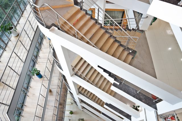 The open feature staircase seen from above, winding through the atrium void.