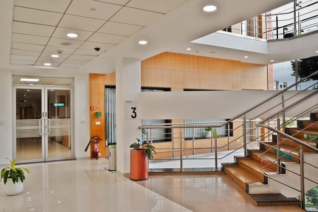 Third floor lift lobby with glazed office entry doors and level signage.