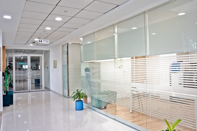 Floor corridor with glazed, fitted meeting rooms and restroom access.