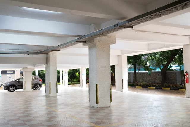 Covered stilt parking at ground level, open on three sides to the landscaped setback.